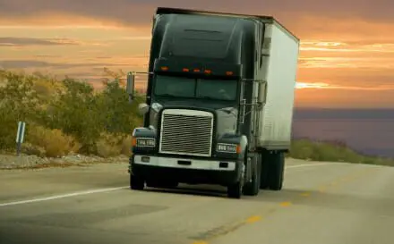 Green 18-Wheeler traveling down open road