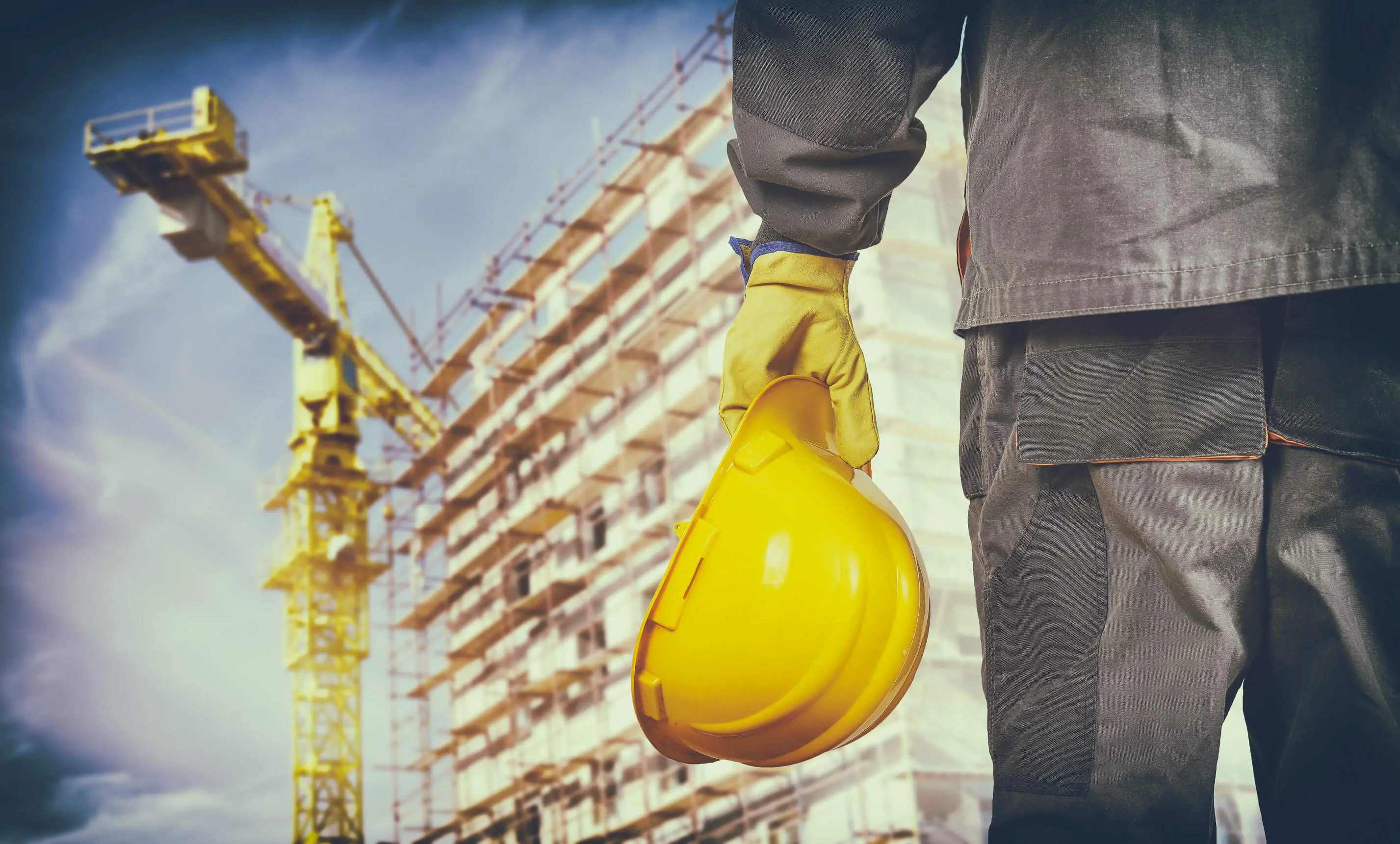 construction worker in protective gear looking toward scaffolding at construction work site