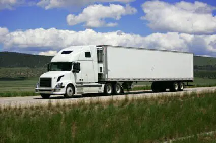 White 18-wheeler traveling down open road