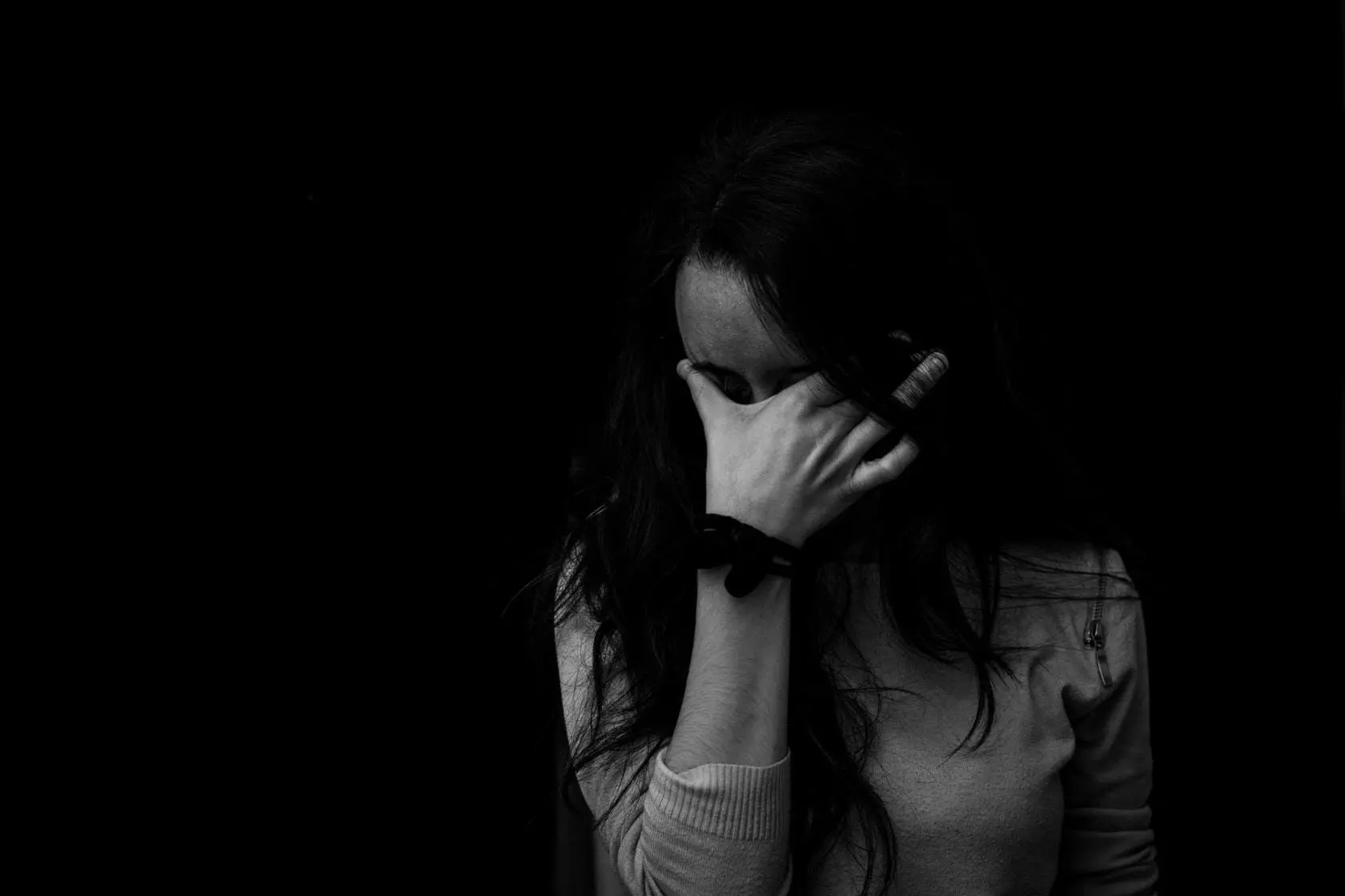 Young woman with head in hands