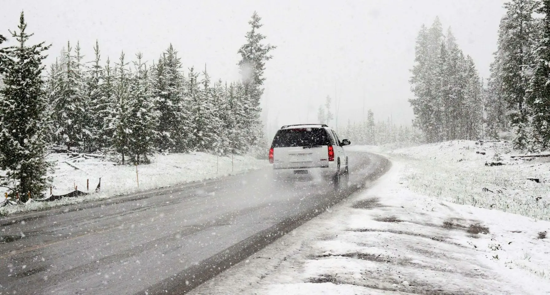 Blog 10 SUV traveling across frozen road in snowy terrain