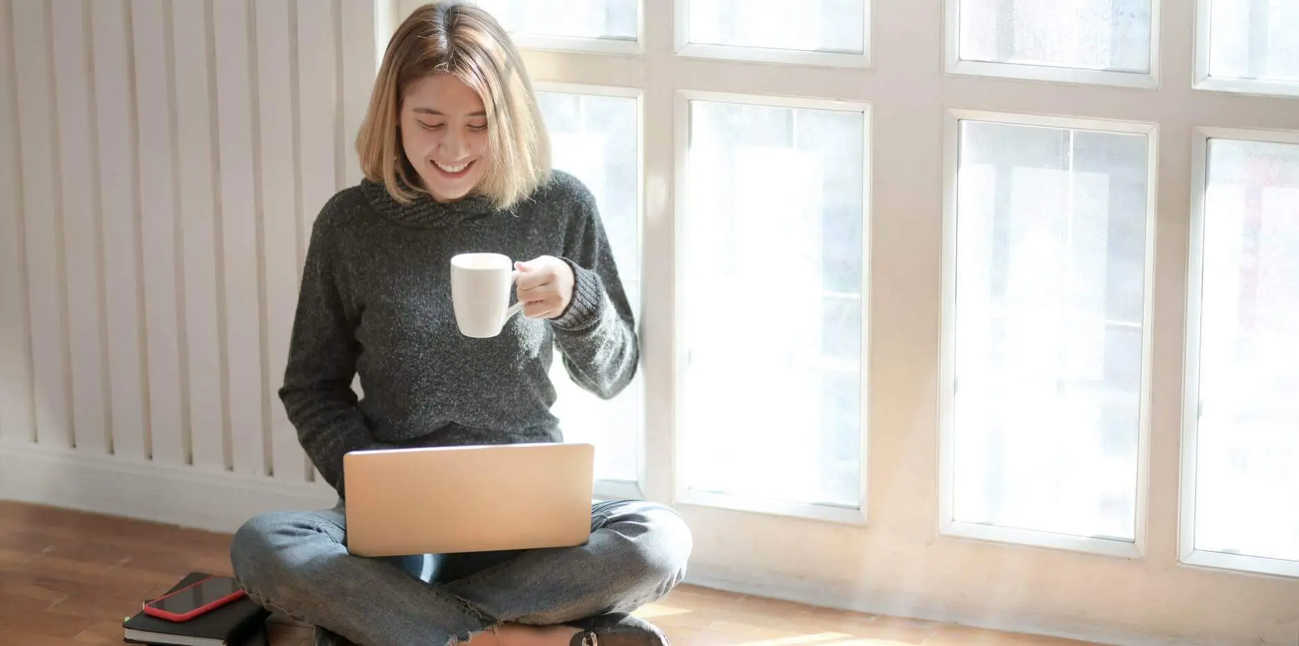 Blog 2 Young woman with cup of coffee on laptop