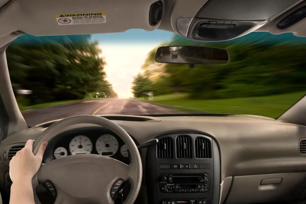 Blog 9 First person view of driver with one hand on the wheel