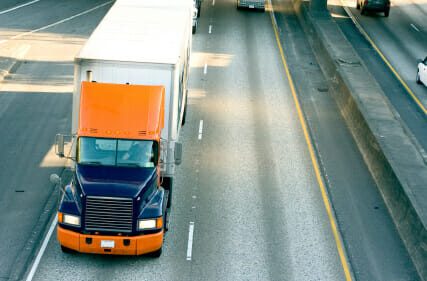 Top view of blue and orange 18-wheeler on highway