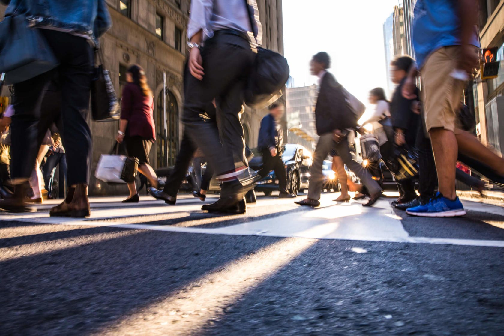 Crowd of pedestrians walking across a crosswalk